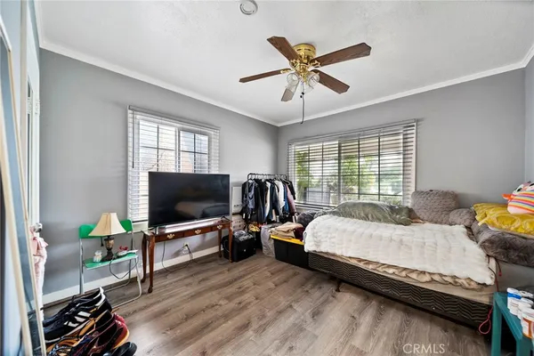 a bedroom with a bed a window and flat screen tv