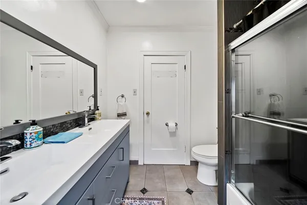 a bathroom with a double vanity sink toilet and shower