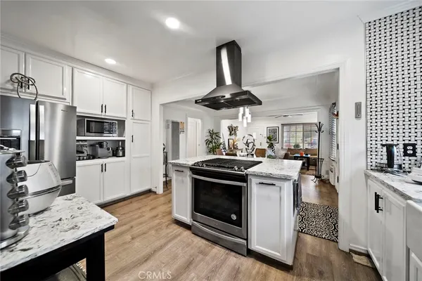 a kitchen with stainless steel appliances a stove refrigerator and white cabinets