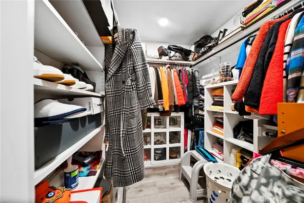 a view of walk in closet with clothes and shoes