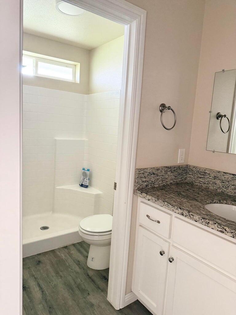 1310 North Belmont Road Exeter, CA 93221 - Photo 11 of 15 a bathroom with a granite countertop sink a toilet and shower