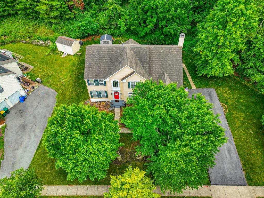 138 Clover Hollow Road Easton, PA 18045 - Photo 91 of 95 An aerial perspective showcases a vibrant green yard with two sheds and a charming home with a red front door.
