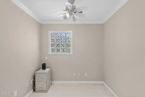 an empty room with a ceiling fan and windows