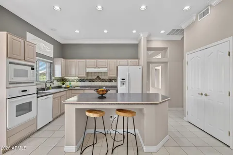 a kitchen with stainless steel appliances granite countertop a refrigerator and a stove top oven