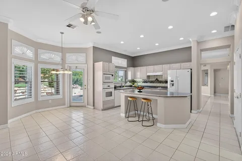 a kitchen with white cabinets and refrigerator