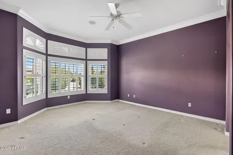 en empty room with windows and ceiling fan