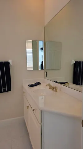 a bathroom with a granite countertop sink and a large mirror