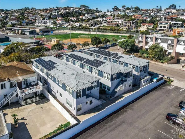 an empty room with wooden floor cabinet and windows