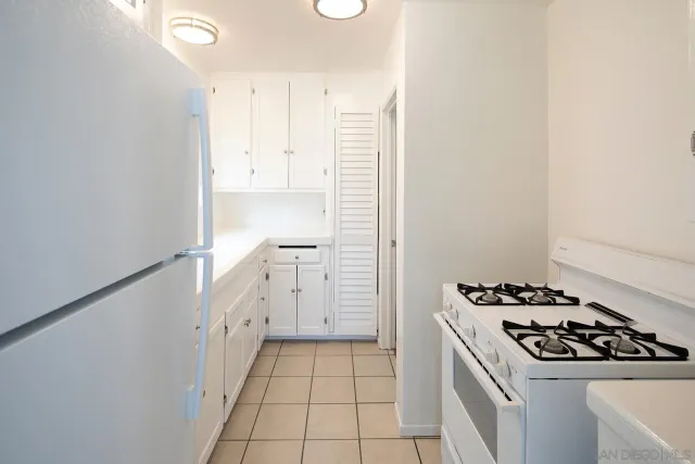 a kitchen with a white cabinets and refrigerator