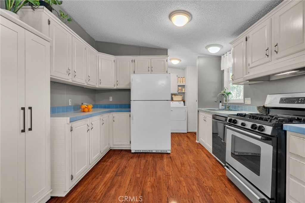 20401 Soledad Canyon Road, Unit 139 Canyon Country, CA 91351 - Photo 12 of 35 a kitchen with white cabinets and white appliances