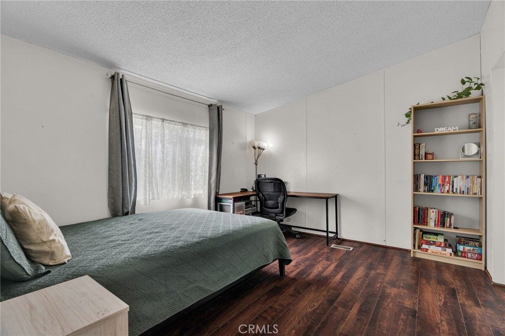 20401 Soledad Canyon Road, Unit 139 Canyon Country, CA 91351 - Photo 25 of 35 a bedroom with a bed and a wooden floor