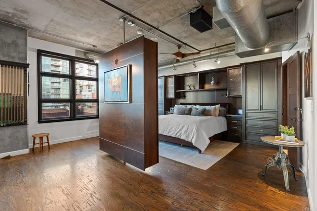 a bedroom with a large bed and windows