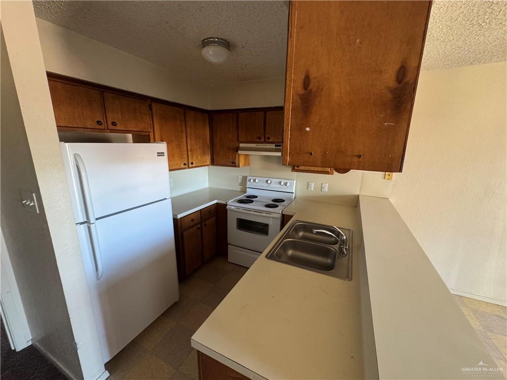 1810 Jason Avenue Edinburg, TX 78539 - Photo 14 of 27 a kitchen with a refrigerator a stove top oven a sink and dishwasher