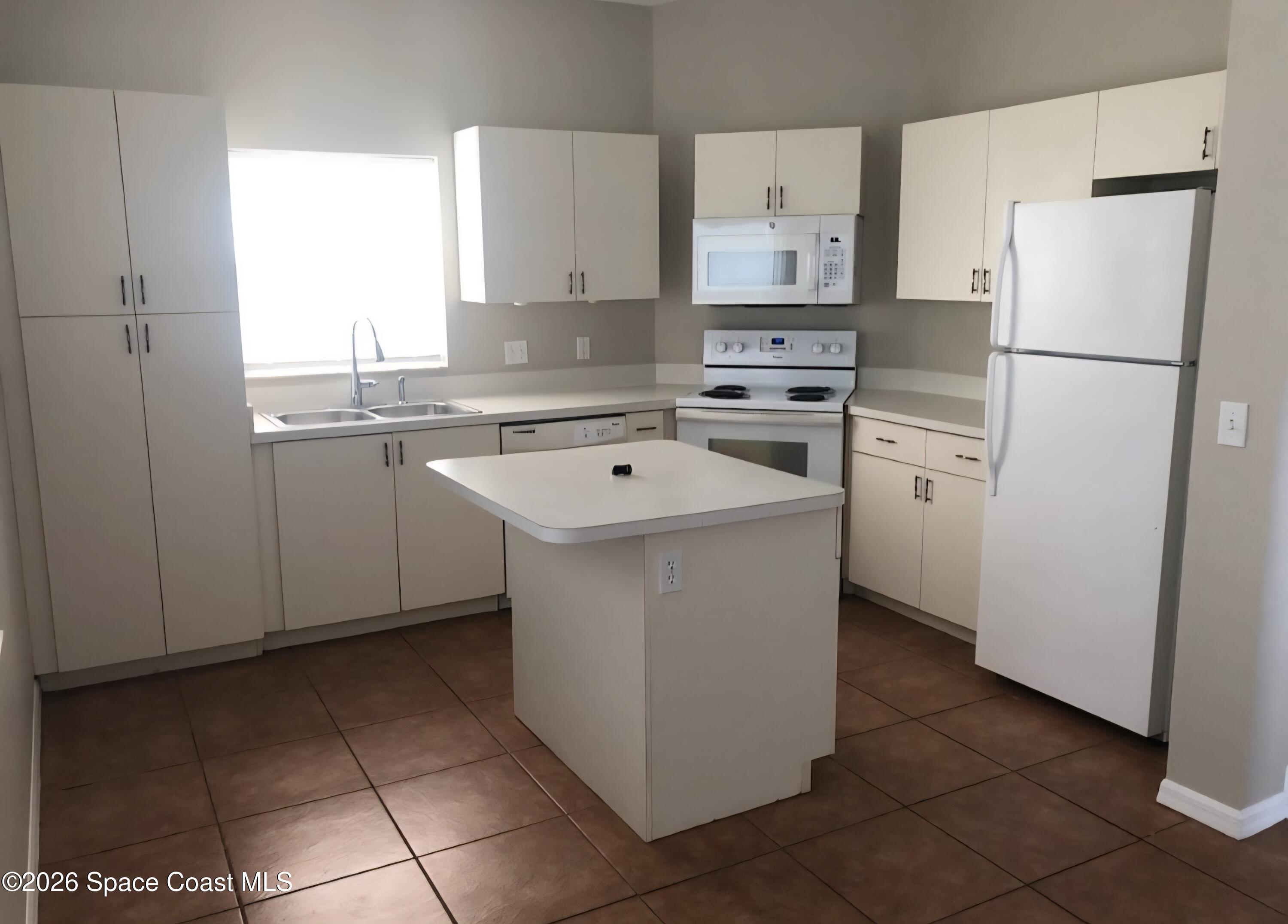 1977 Myrtle Court Palm Bay, FL 32905 - Photo 5 of 19 a white refrigerator freezer sitting inside of a kitchen