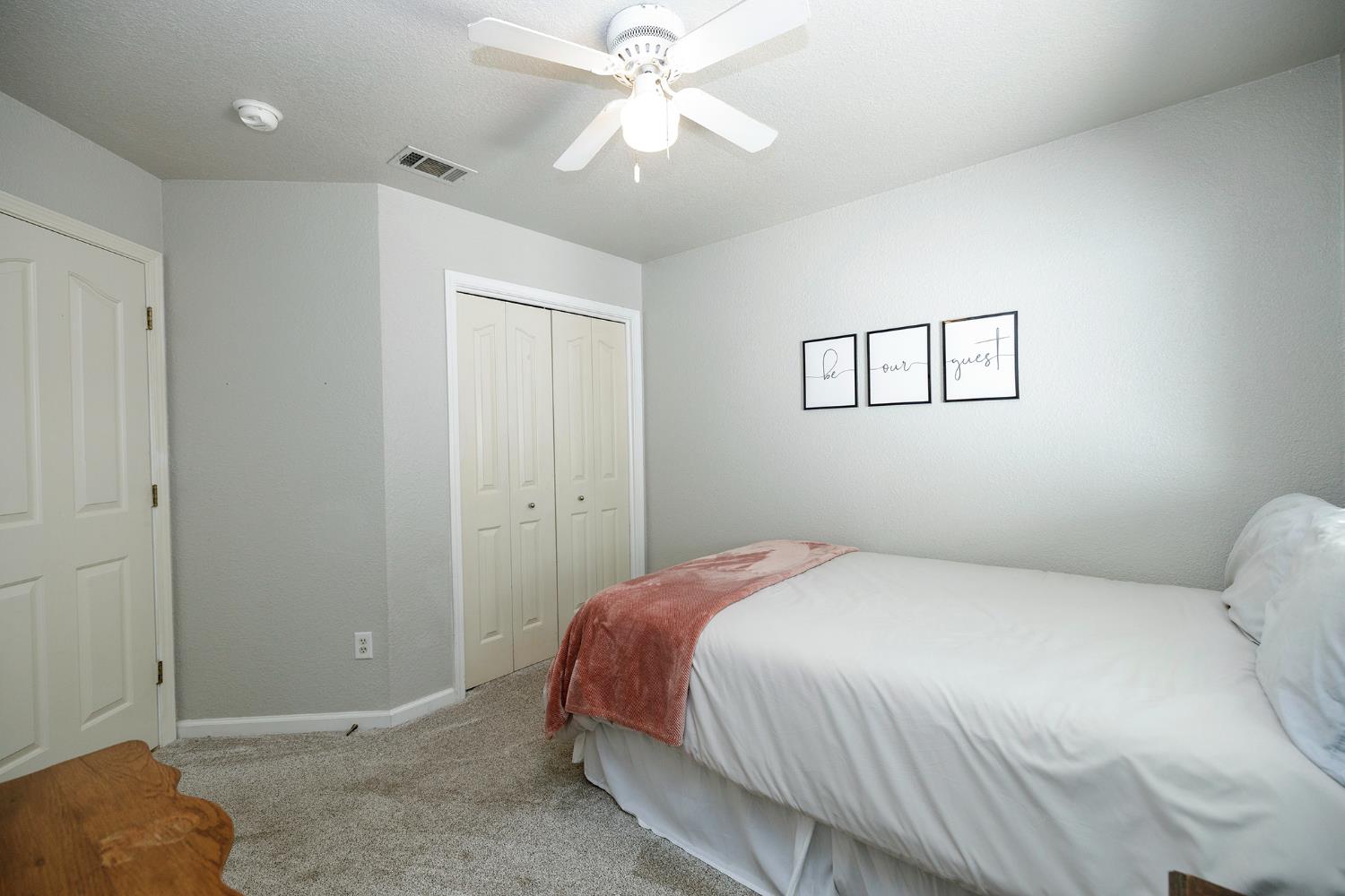 230 Meyenberg Avenue Ripon, CA 95366 - Photo 39 of 52 a bedroom with a bed and a chandelier