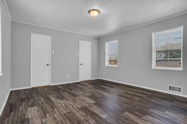 a view of empty room with wooden floor