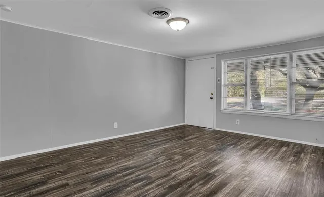 wooden floor in an empty room with a window