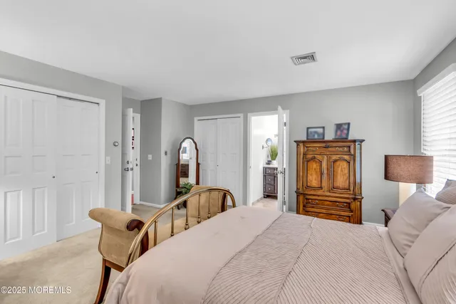 a bedroom with a bed and a dresser with mirror