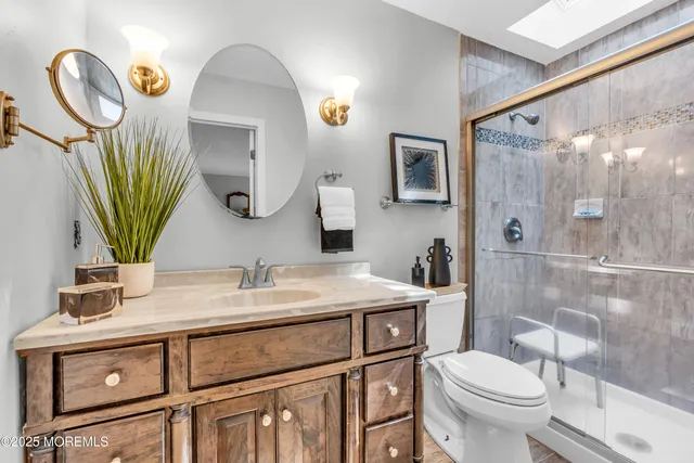 a bathroom with a granite countertop toilet sink and mirror