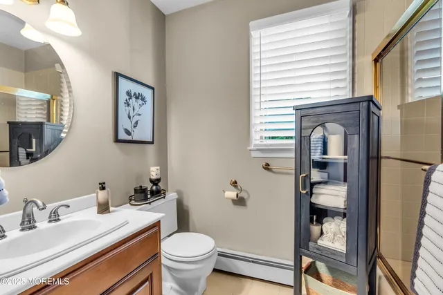 a bathroom with a granite countertop toilet sink and mirror