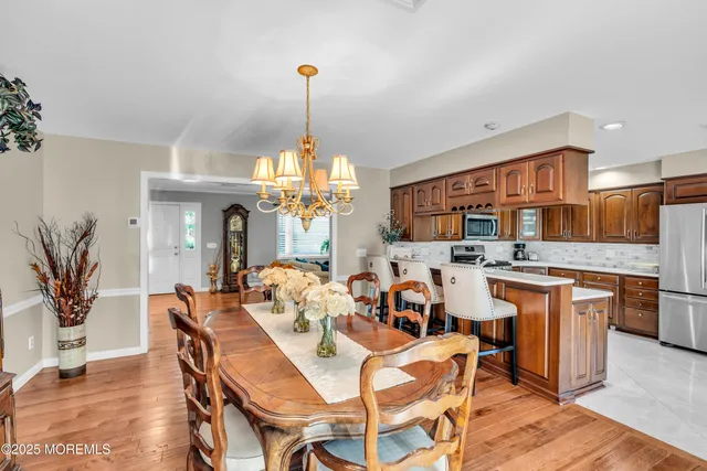 a view of a dining room and livingroom with furniture wooden floor a chandelier