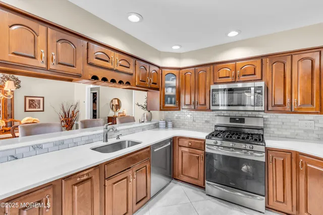a kitchen with stainless steel appliances granite countertop a stove a sink and a microwave