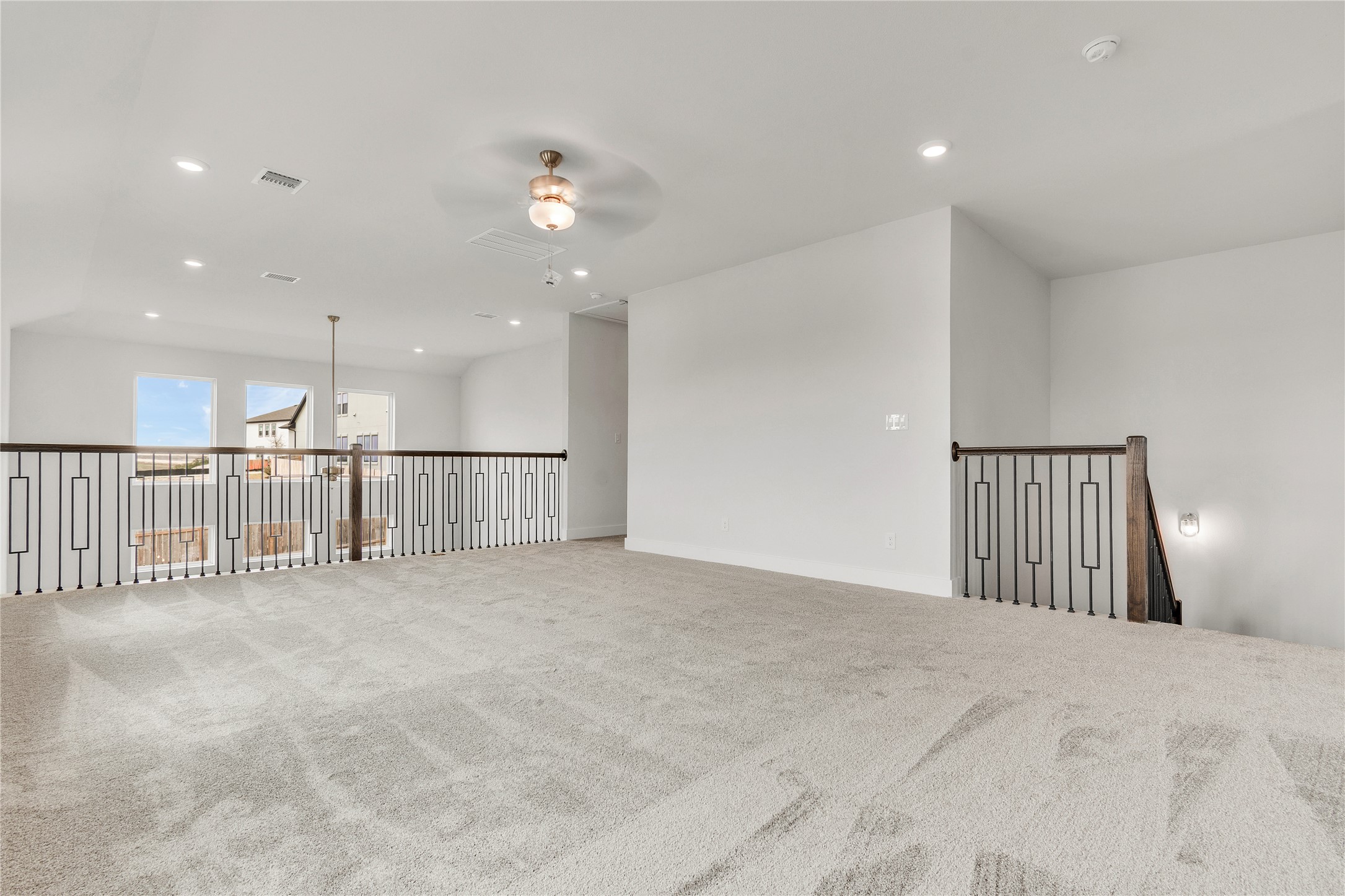 8500 Red Bottle Brush Road Lago Vista, TX 78645 - Photo 15 of 33 An airy loft area with plush carpet and modern railings overlooks the main living space.