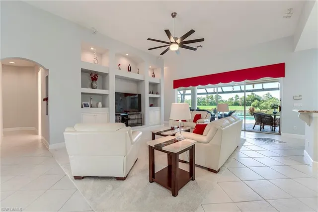 a living room with patio furniture and a floor to ceiling window