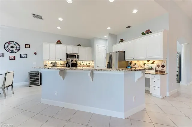 a kitchen with white cabinets and window