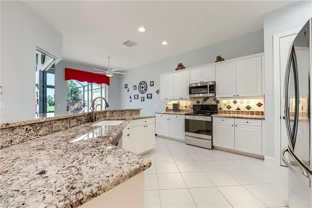 a kitchen with stainless steel appliances granite countertop a stove a sink and a refrigerator