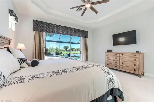 a bedroom with a bed and a flat tv screen on dresser