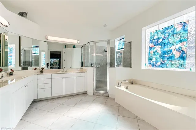 a large white bathroom with a bathtub and a sink