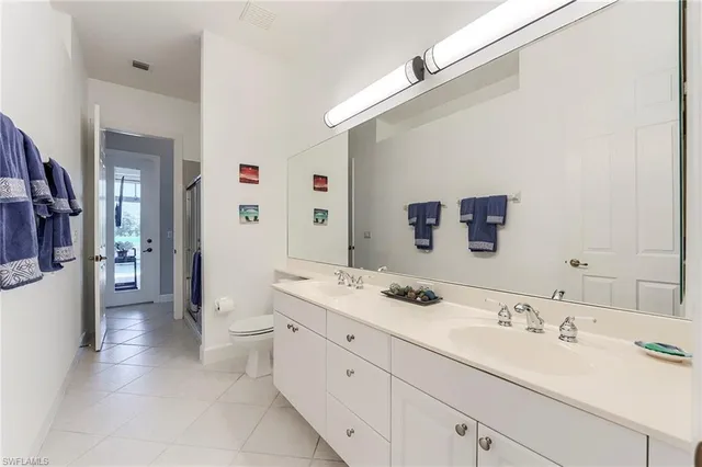 a spacious bathroom with a double vanity sink mirror and toilet