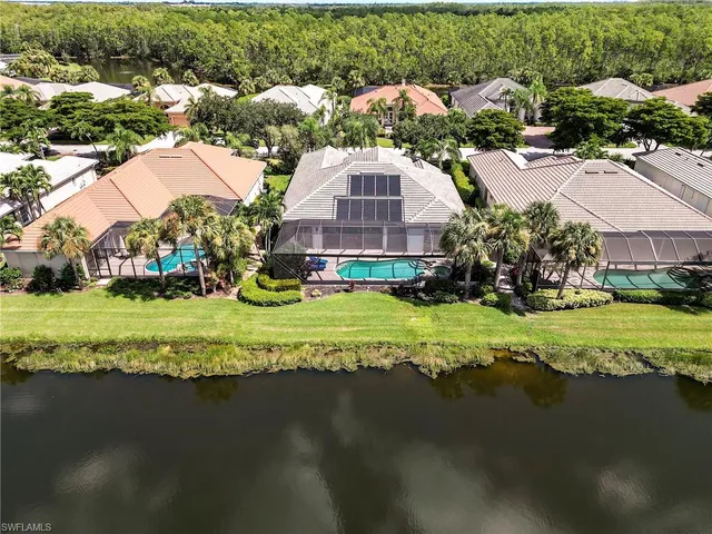 an aerial view of residential houses with outdoor space and trees