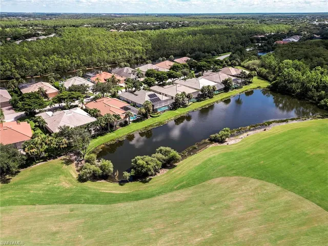 an aerial view of residential houses with outdoor space and trees