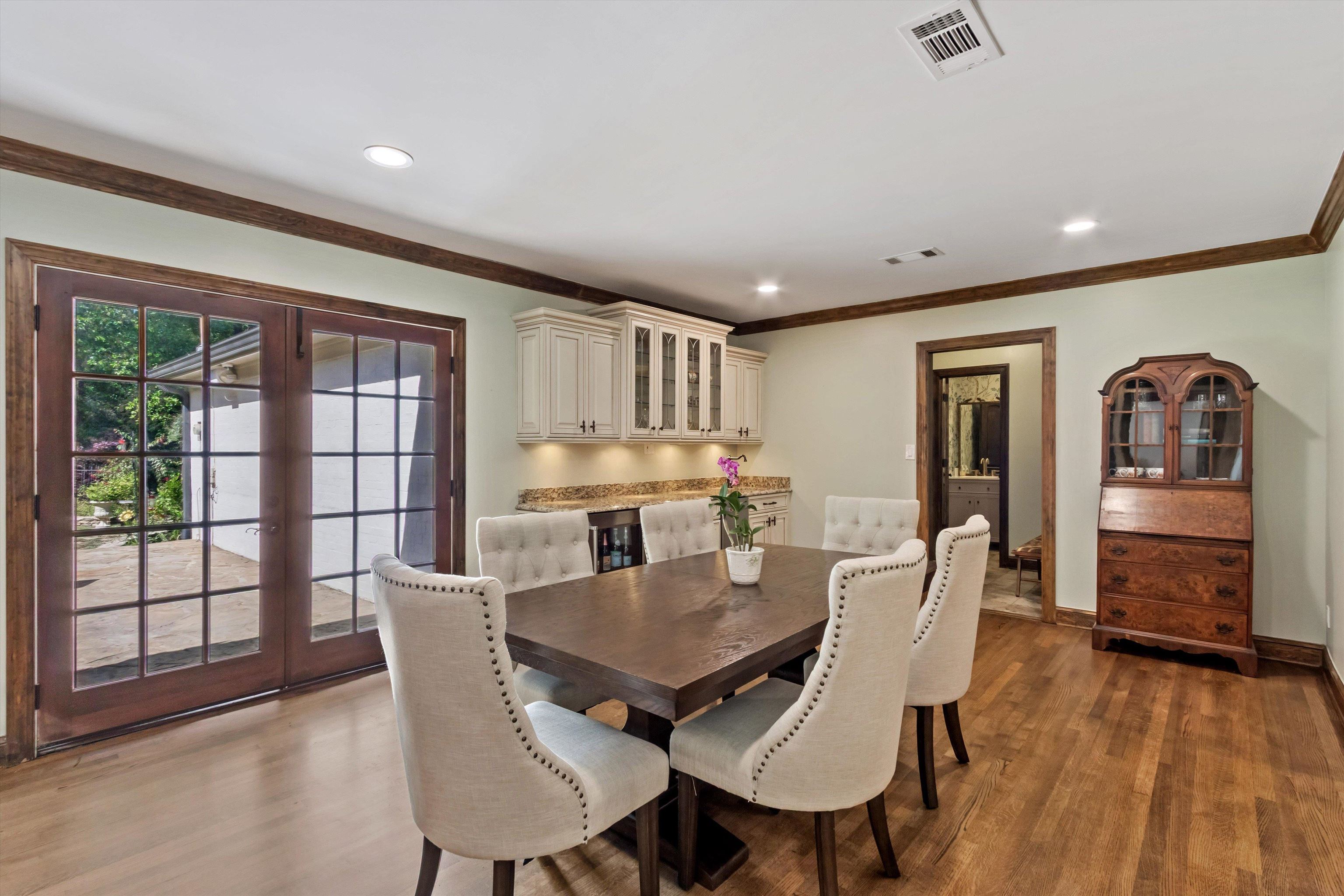 5302 South Angela Road Memphis, TN 38120 - Photo 14 of 40 Wood-finish flooring throughout, featuring a built-in beverage bar with cream cabinetry and a stone-finish countertop