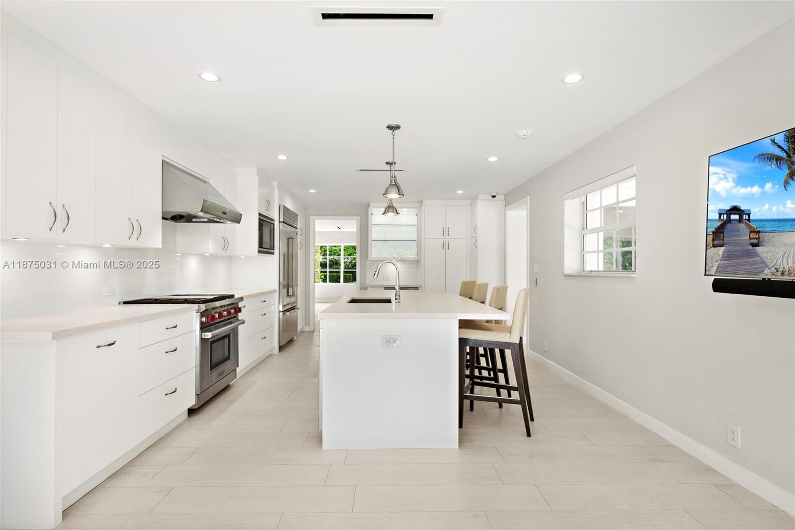 4380 Lake Road Miami, FL 33137 - Photo 11 of 61 a kitchen with white cabinets and appliances