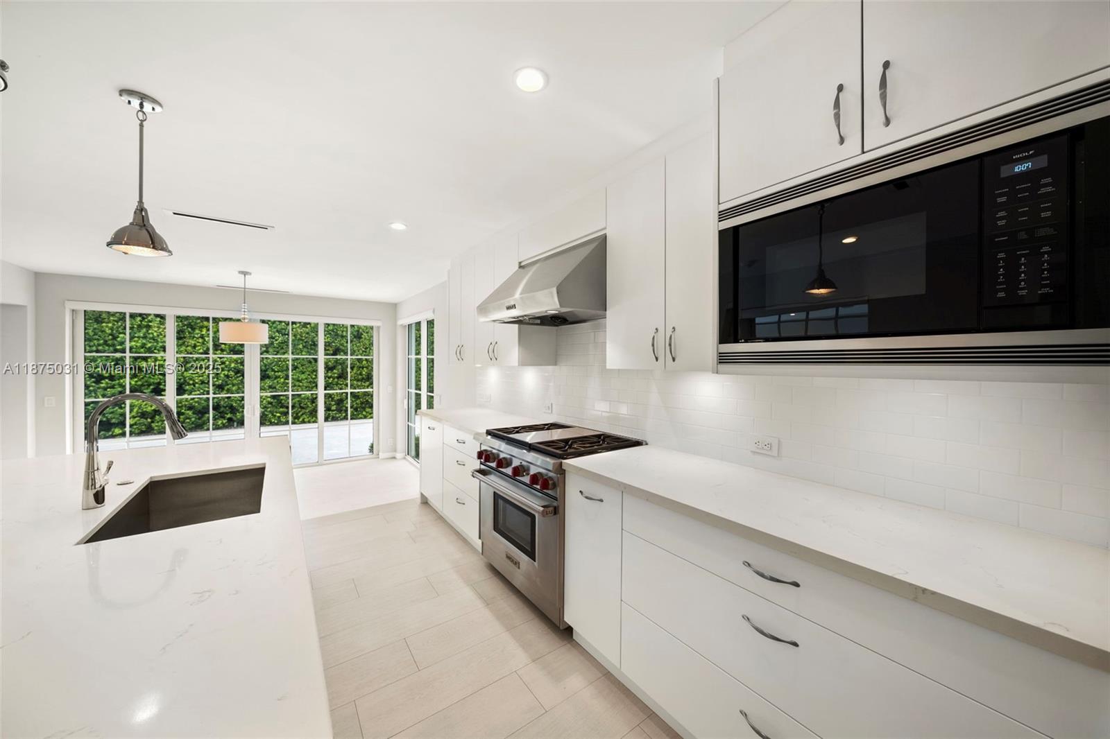 4380 Lake Road Miami, FL 33137 - Photo 12 of 61 a kitchen with stainless steel appliances granite countertop a stove a sink and a microwave