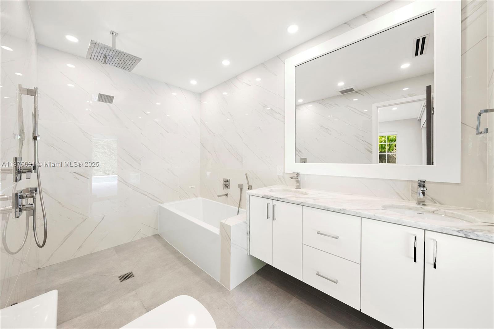 4380 Lake Road Miami, FL 33137 - Photo 28 of 61 a spacious bathroom with a bathtub shower sink double and mirror