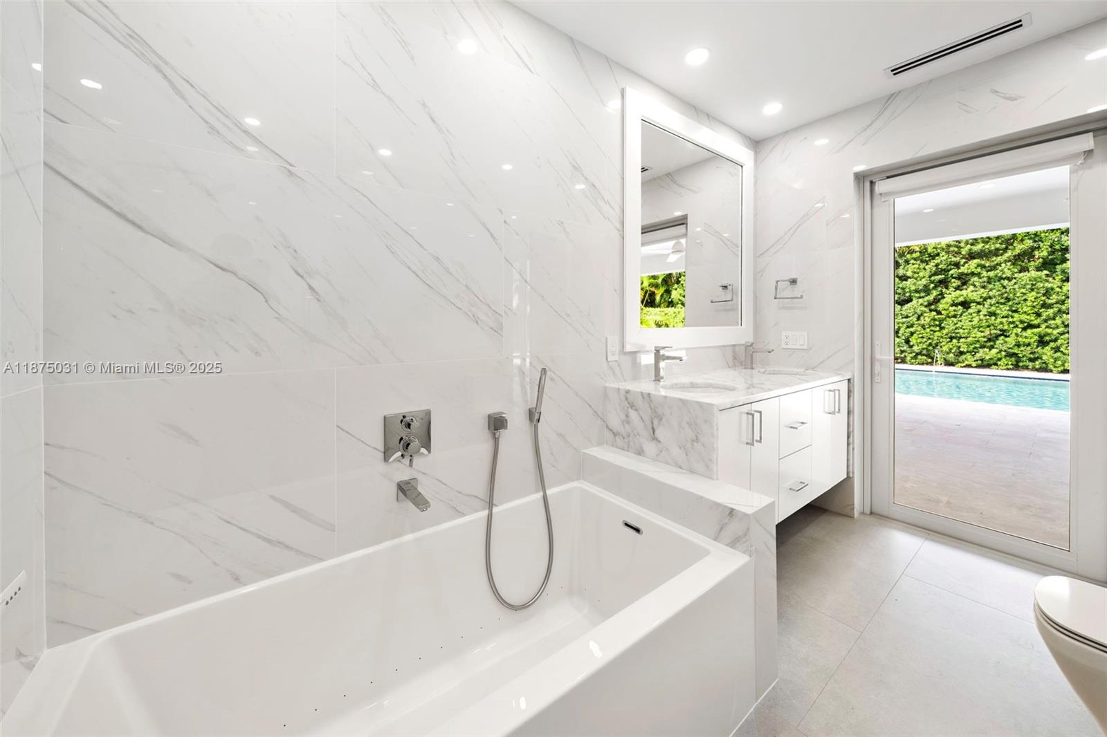 4380 Lake Road Miami, FL 33137 - Photo 30 of 61 a bathroom with a bathtub a sink a window and a shower