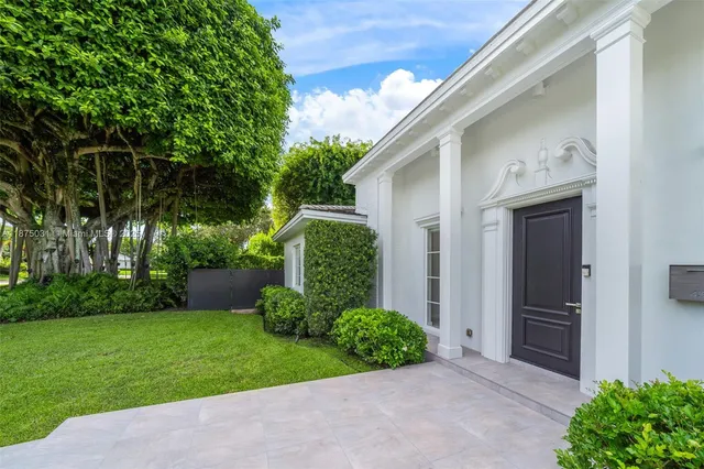 a view of an empty room with wooden floor and a large window