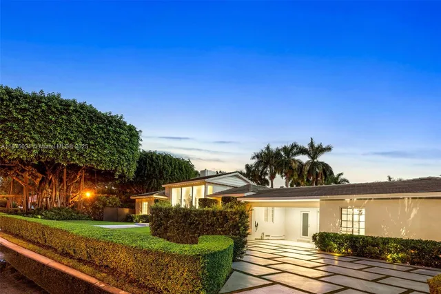 an aerial view of a house with a garden and lake view