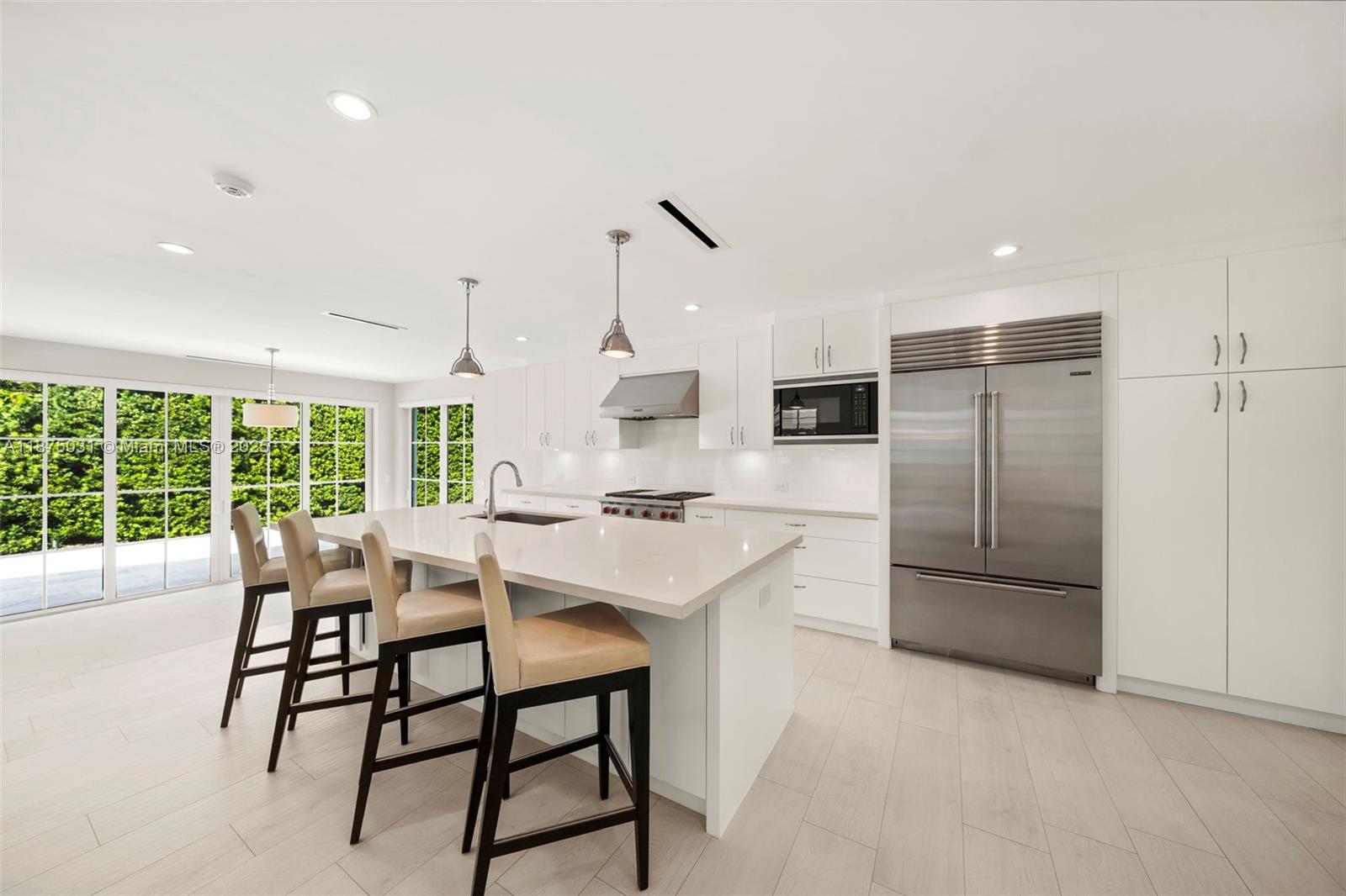 4380 Lake Road Miami, FL 33137 - Photo 10 of 61 a kitchen with stainless steel appliances kitchen island granite countertop a refrigerator and a stove top oven