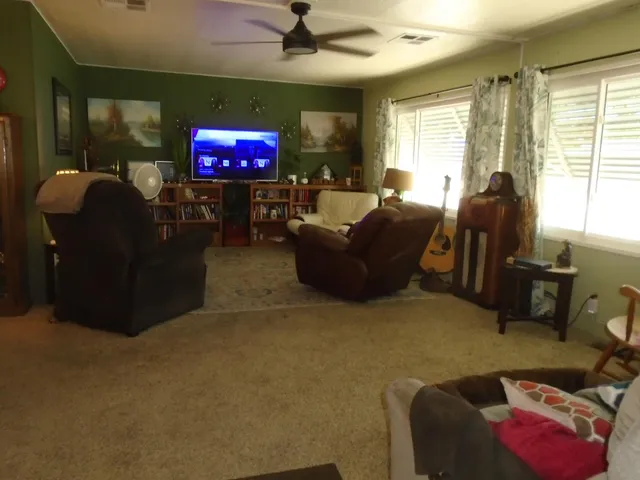 a living room with furniture a projector and a window
