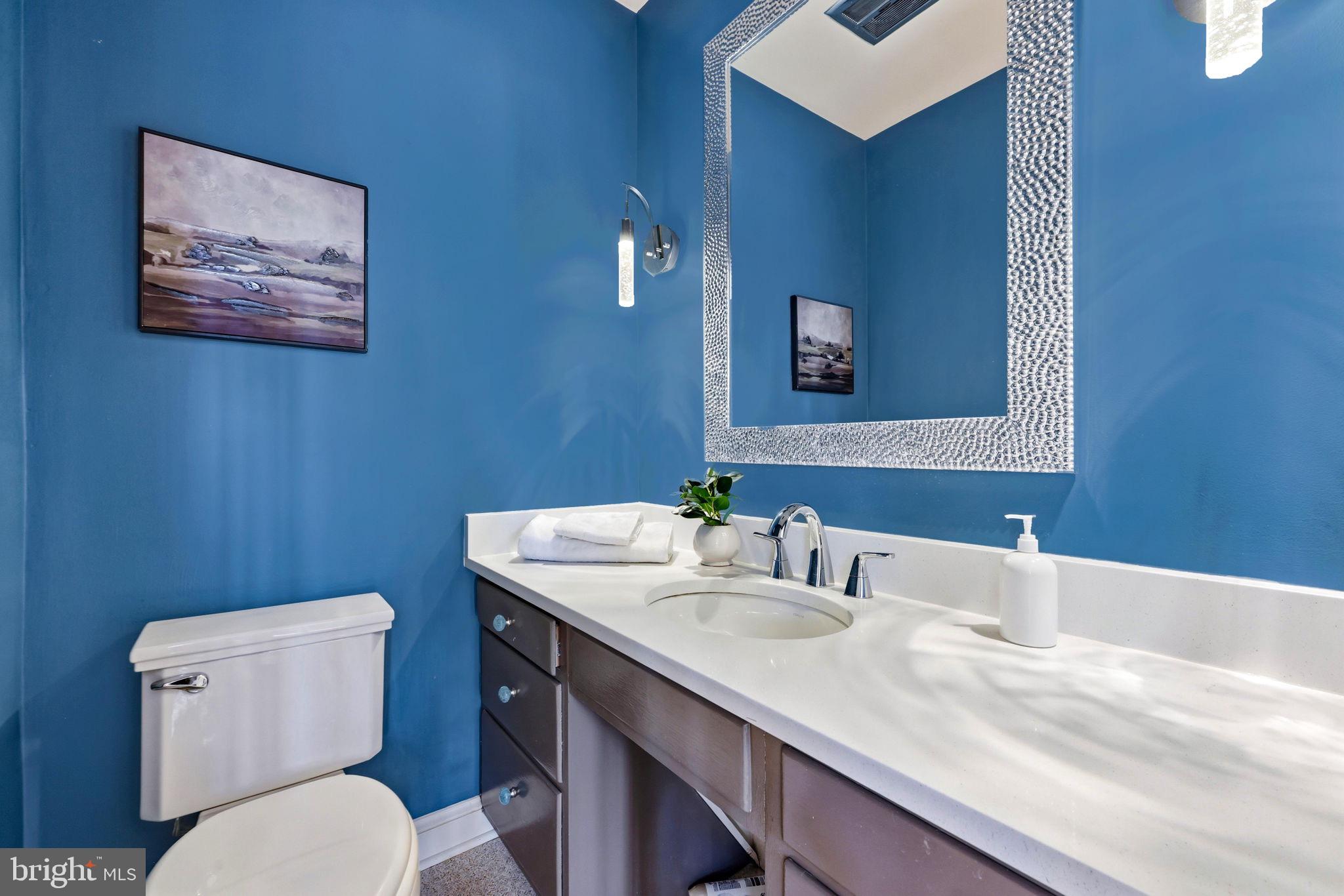 9101 Warfield Road Gaithersburg, MD 20882 - Photo 21 of 44 a bathroom with a toilet a sink and mirror