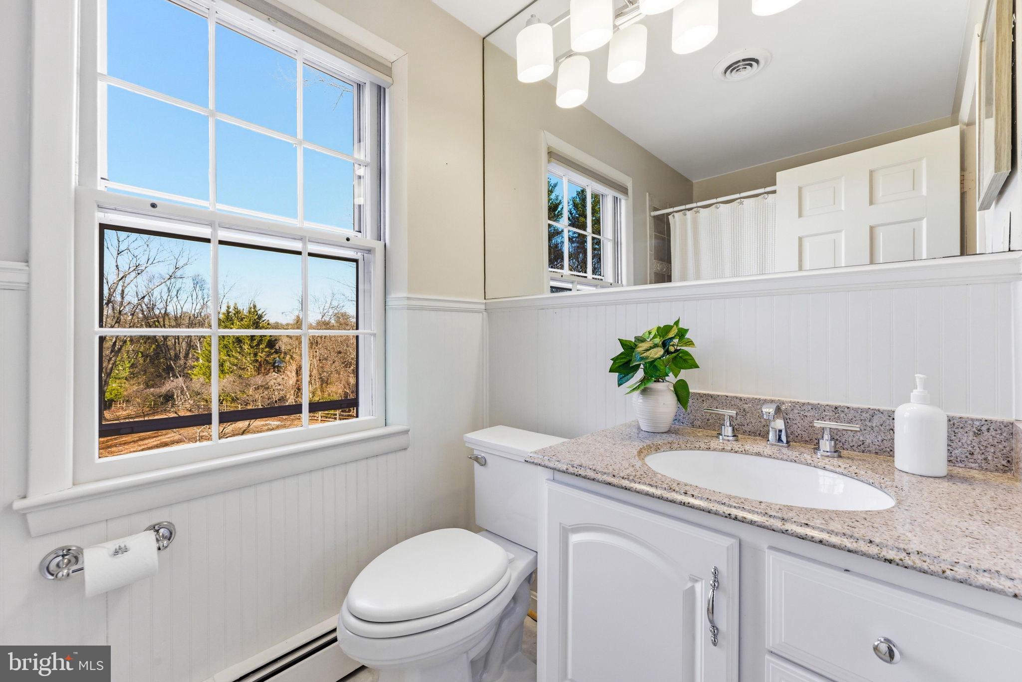 9101 Warfield Road Gaithersburg, MD 20882 - Photo 29 of 44 a bathroom with a granite countertop sink mirror vanity and toilet