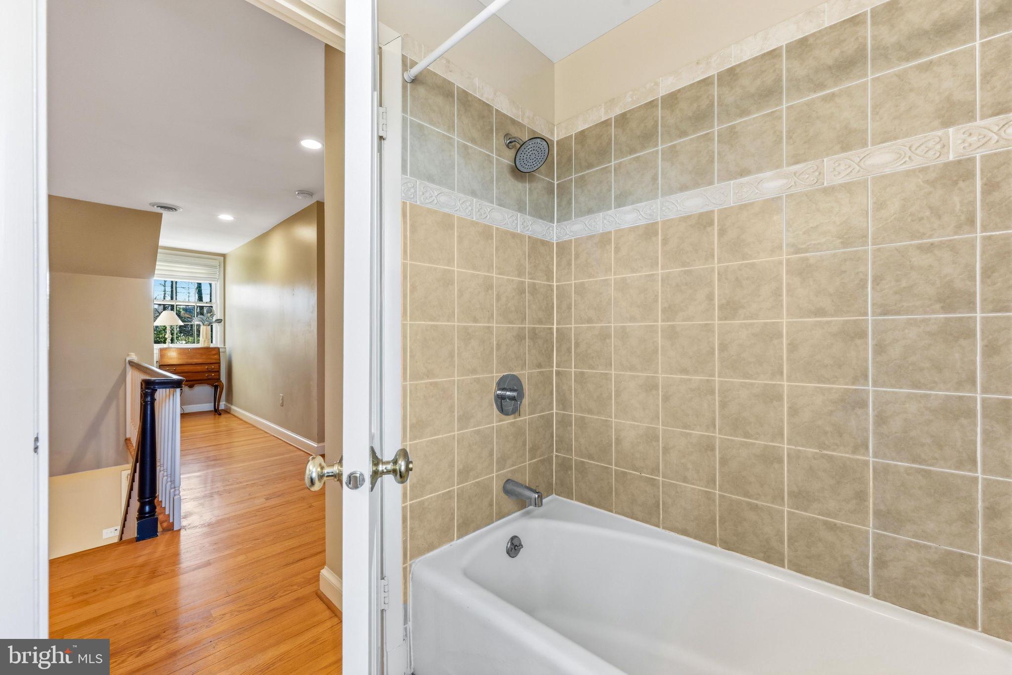 9101 Warfield Road Gaithersburg, MD 20882 - Photo 30 of 44 a bathroom with a bathtub and a shower