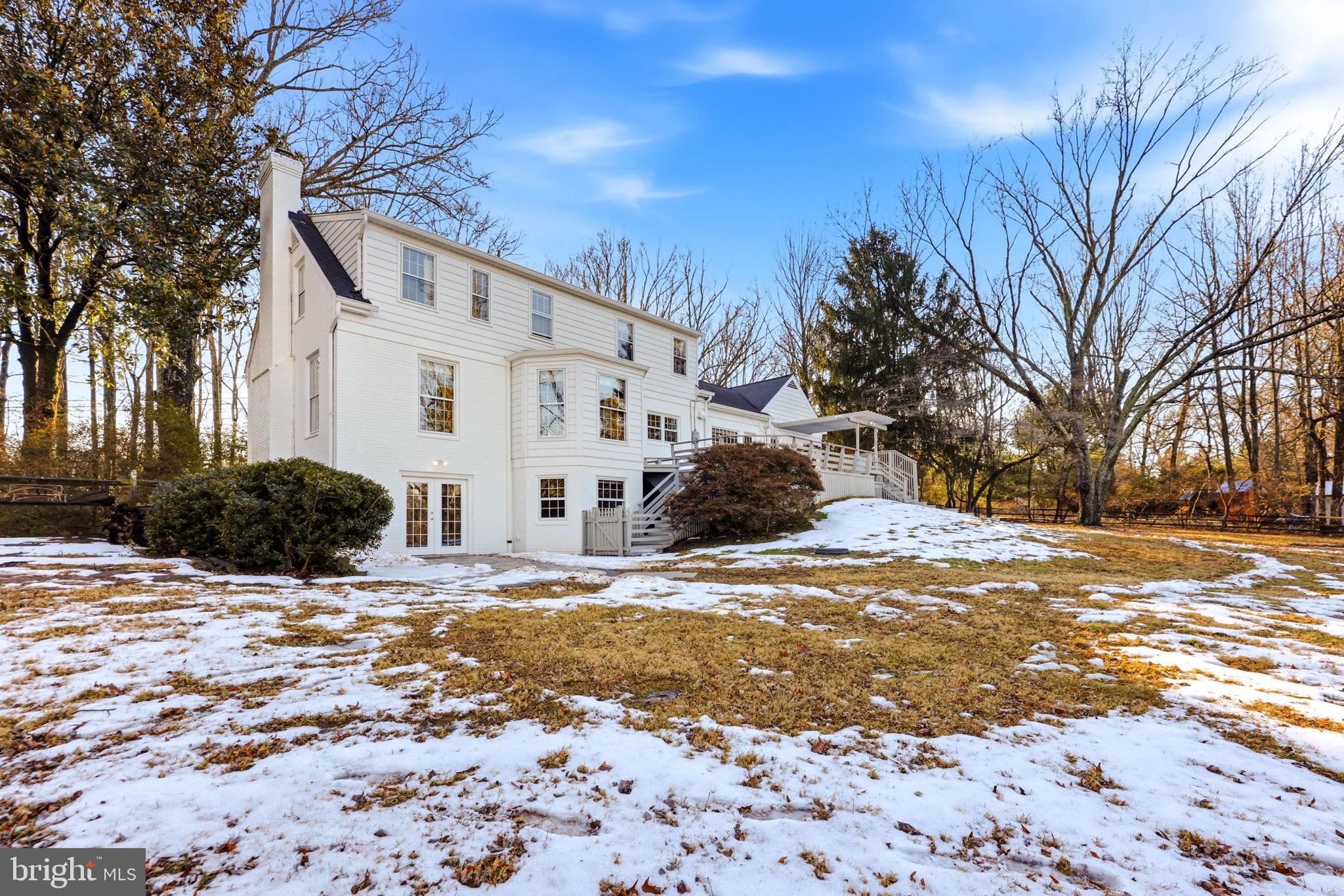 9101 Warfield Road Gaithersburg, MD 20882 - Photo 35 of 44 a view of a white house with a yard covered in snow