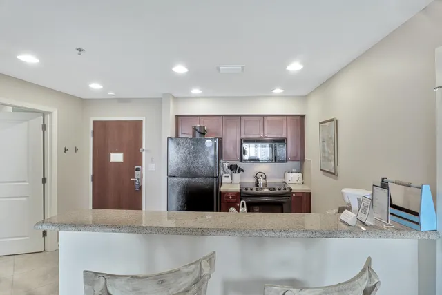 a kitchen with stainless steel appliances granite countertop a refrigerator and a sink