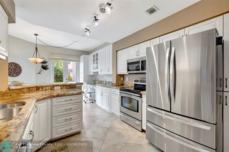 a kitchen with granite countertop cabinets stainless steel appliances and a counter space